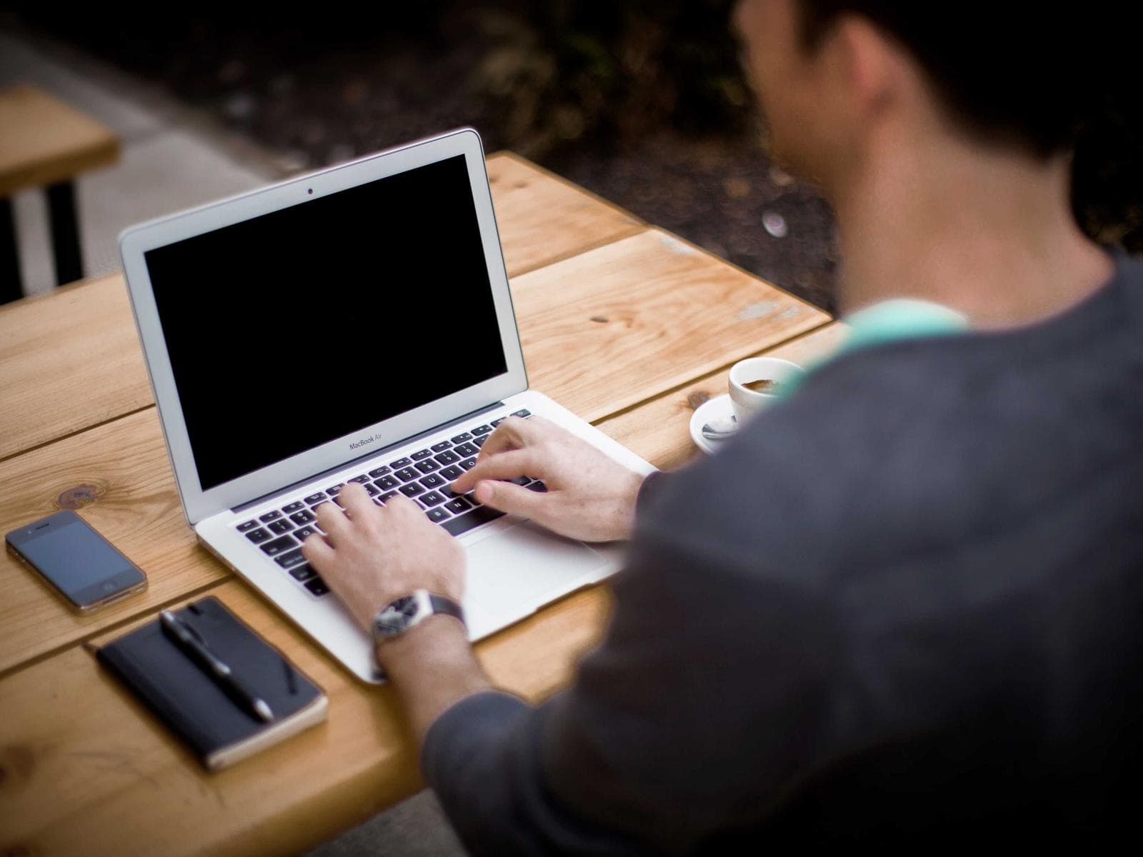 A team member working at a laptop, seen from behind
